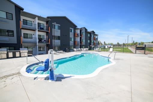 a swimming pool with an apartment building in the background