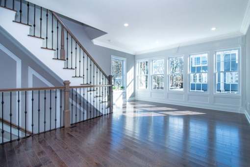 a living room with a staircase and a hard wood floor
