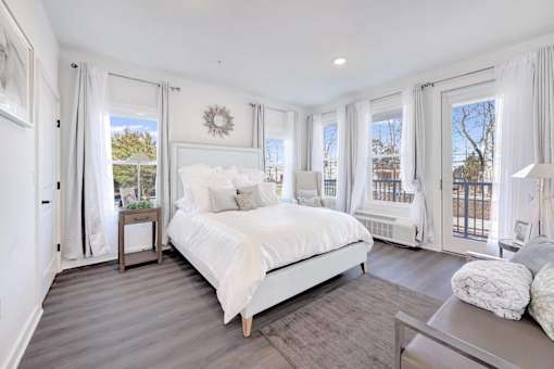a white bedroom with a large bed and windows at The Franklin at Hillsborough Apartments, Hillsborough, New Jersey