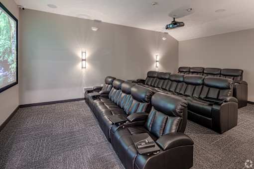 A black leather sofa in a room with a projector screen.