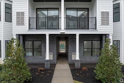 A white two-story building with a balcony in the middle.