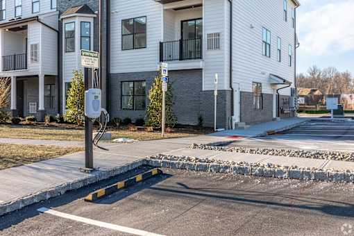A street view of a residential area with apartment buildings and a parking meter.