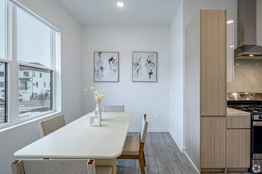 A dining room with a table and chairs.