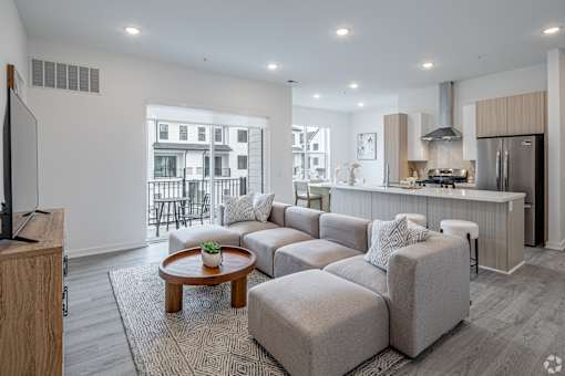 A modern living room with a grey sofa set and a wooden coffee table.
