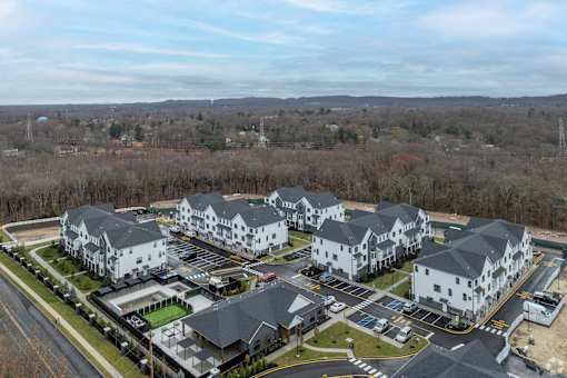 A large white building complex with a parking lot in front.