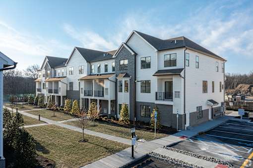 A row of modern houses with a clear blue sky above them.