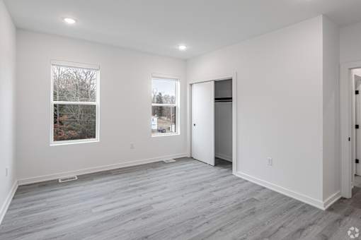 A large empty room with a window and a door.