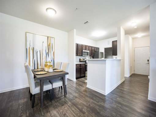 a dining room and kitchen with a table and chairs at The Maddox Apartments, Centerton, AR
