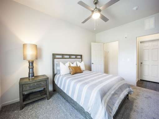 a bedroom with a bed and a ceiling fan at The Maddox Apartments, Centerton