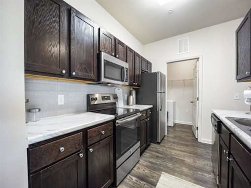 a kitchen with a stove refrigerator and a microwave at The Maddox Apartments, Centerton, AR