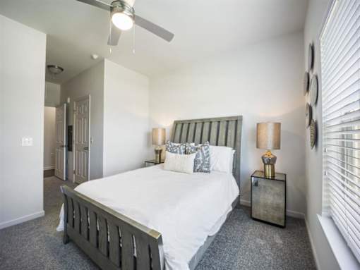 a bedroom with a bed and a ceiling fan at The Maddox Apartments, Centerton, AR