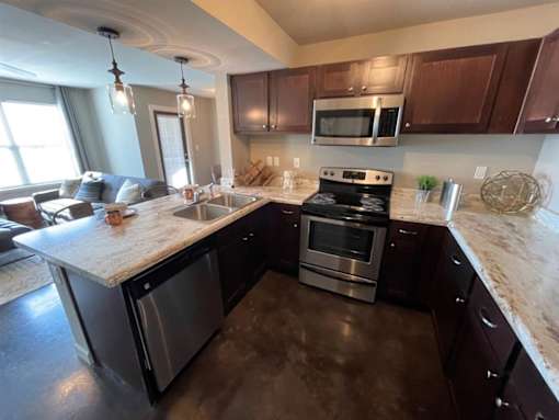 a kitchen with stainless steel appliances and a marble counter top