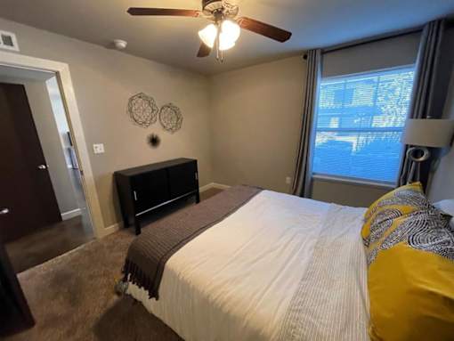 a bedroom with a bed and a ceiling fan