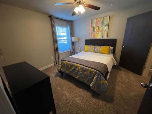 a bedroom with a bed and a ceiling fan
