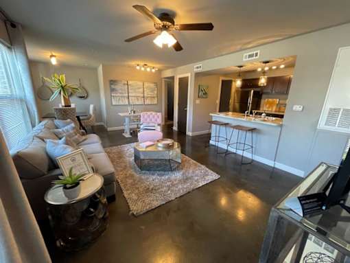 a living room and kitchen with a ceiling fan