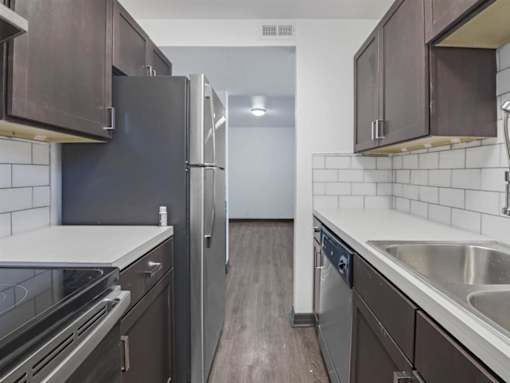 a kitchen with stainless steel appliances and wooden floors