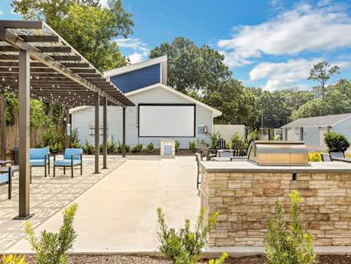 the outdoor entertaining area of a home with a pool and a movie screen