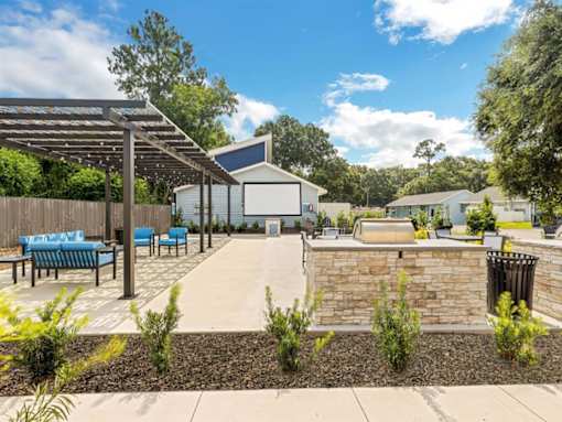 a patio with a stone wall and a fire pit
