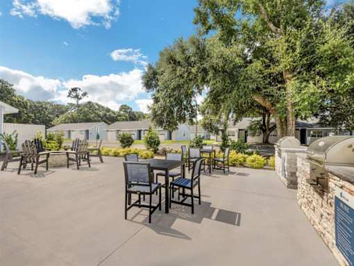 an outdoor patio with tables and chairs and trees