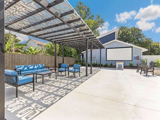 a covered patio with blue chairs and a projector screen