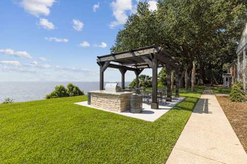 a picnic area with a grill and a view of the water