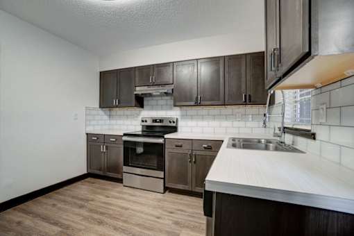 an empty kitchen with wooden cabinets and a sink