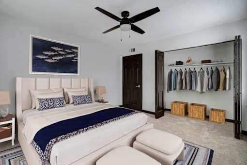 a bedroom with a bed and a ceiling fan