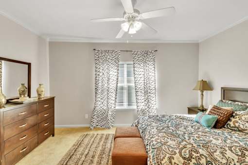 a bedroom with a bed and a ceiling fan