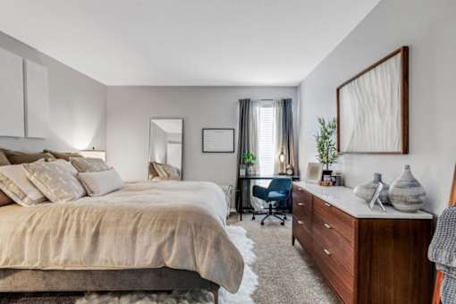 A bedroom with a large bed and a desk with a chair. at The Beacon, Alabama