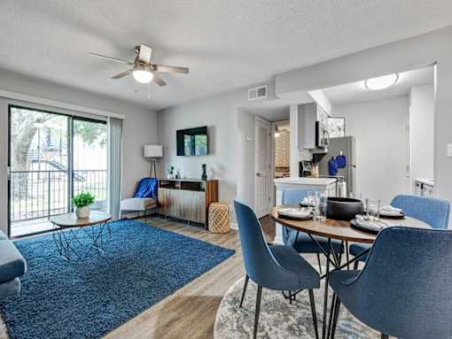 a living room and dining room with a sliding glass door