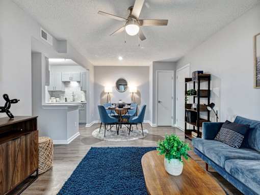 a living room and dining room with a ceiling fan