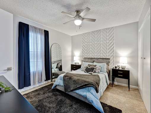 a bedroom with a bed and a ceiling fan