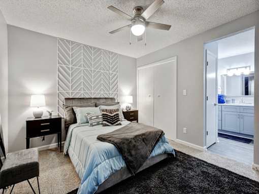 a bedroom with a large bed and a ceiling fan