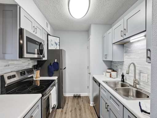 a kitchen with white cabinets and stainless steel appliances