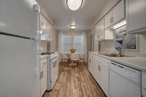a large white kitchen with white cabinets and a wood floor at Estates at Palm Bay, Fort Walton Beach, 32547