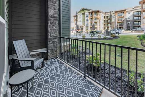 a patio with a chair and a table on a balcony