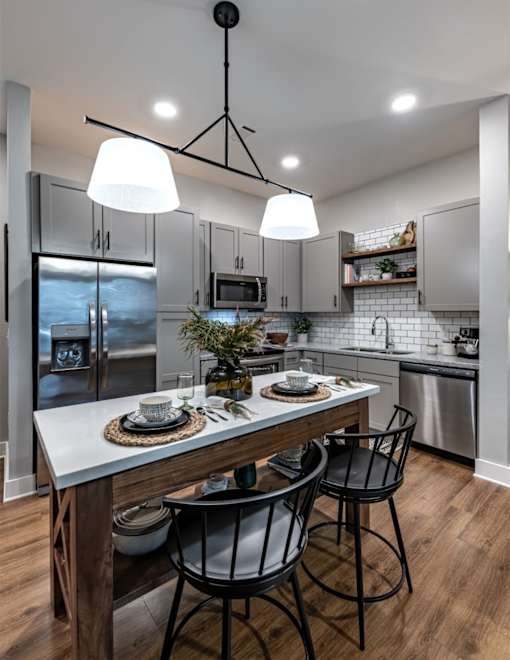 a kitchen with a large island with three chairs