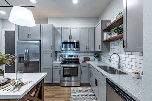 a kitchen with white cabinets and stainless steel appliances