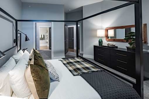 a bedroom with a bed and a dresser and a mirror