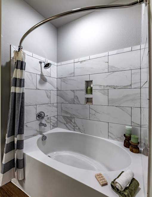 a white bathroom with a tub and a shower curtain