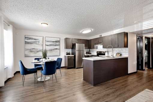 a kitchen and dining room with a table and chairs at The Lorient Apartments, Pensacola, FL, 32514
