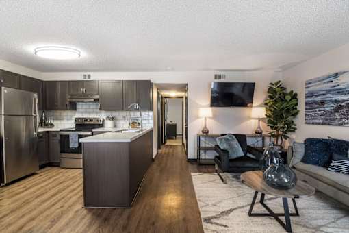 a living room and kitchen with a couch and a table at The Lorient Apartments, Pensacola, FL