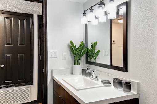 a bathroom with a sink and a mirror at The Lorient Apartments, Pensacola, Florida