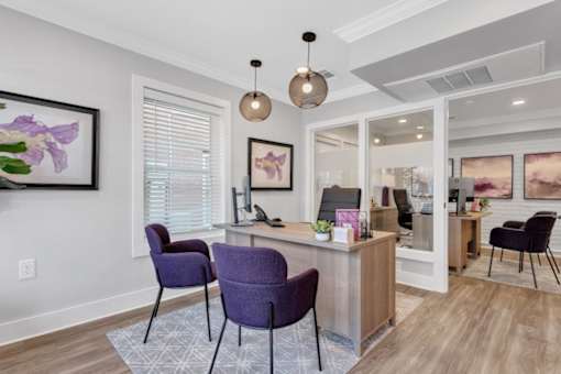 a living room with purple chairs and a reception desk