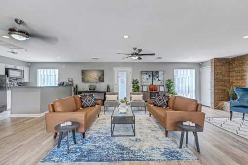 A living room with a blue rug and brown couches.