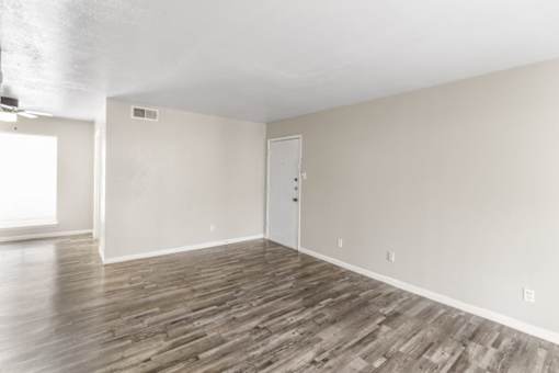 A room with wooden flooring and a white door.