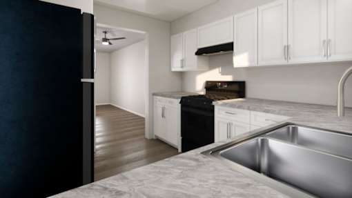 A modern kitchen with a black refrigerator and white cabinets.