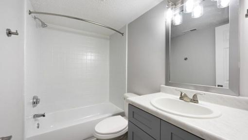 A white bathroom with a toilet, sink, and bathtub.