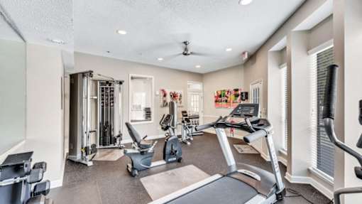 A spacious gym with treadmills, weights, and exercise equipment.