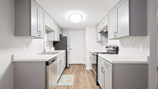 A kitchen with white cabinets and a white counter top.